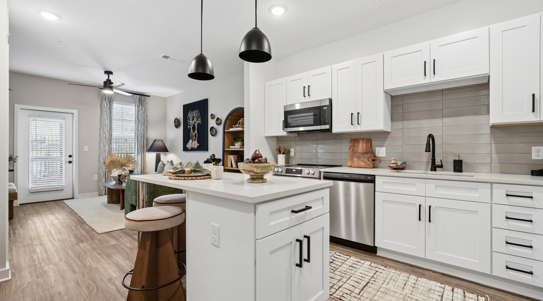 Apartment kitchen with white cabinetry, stainless steel appliances and island