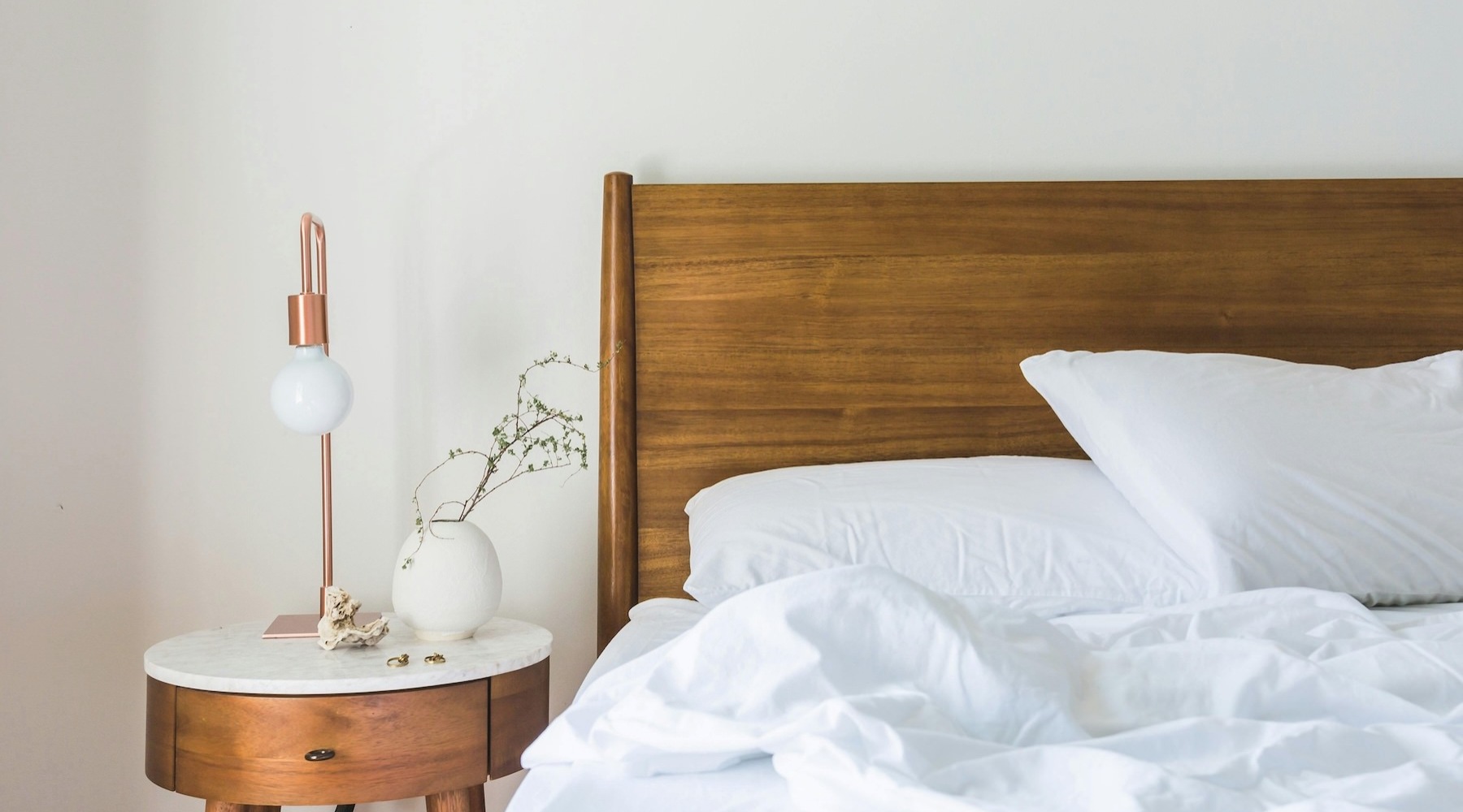 a bedroom with a bed, nightstand and a lamp